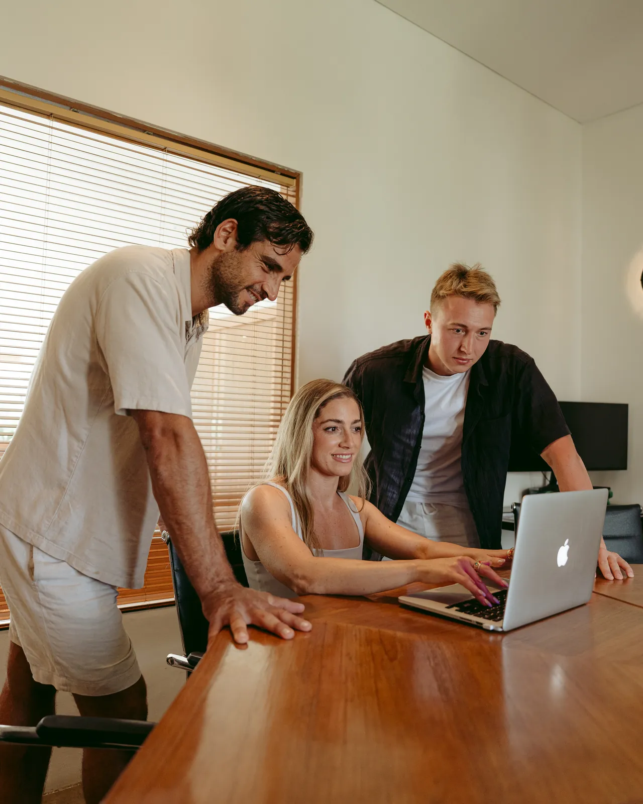 Three guests working together at a table in a private office