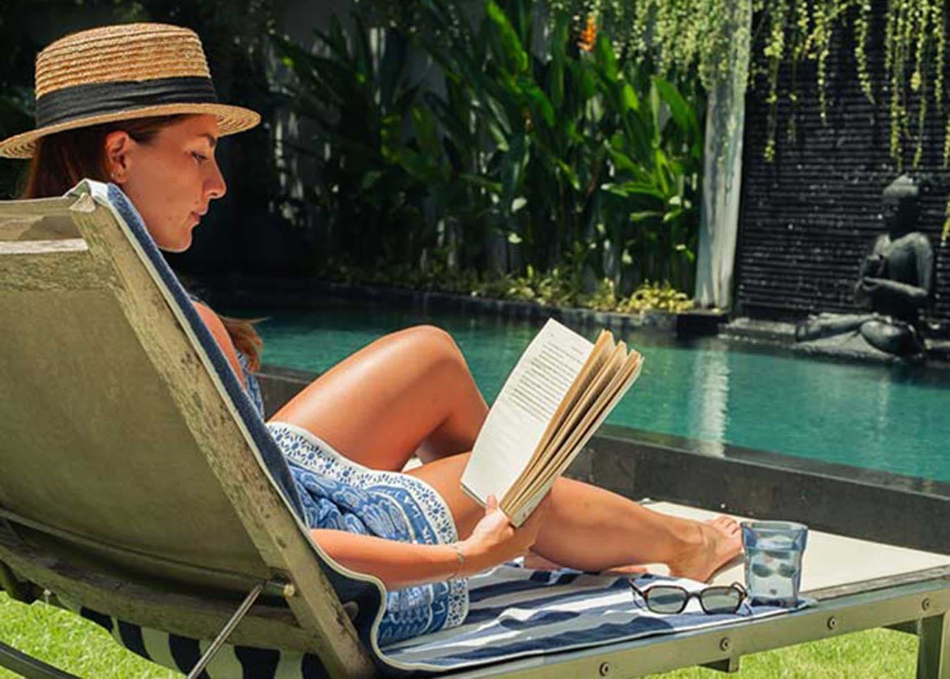 A guest reading beside a private pool at Pronoia