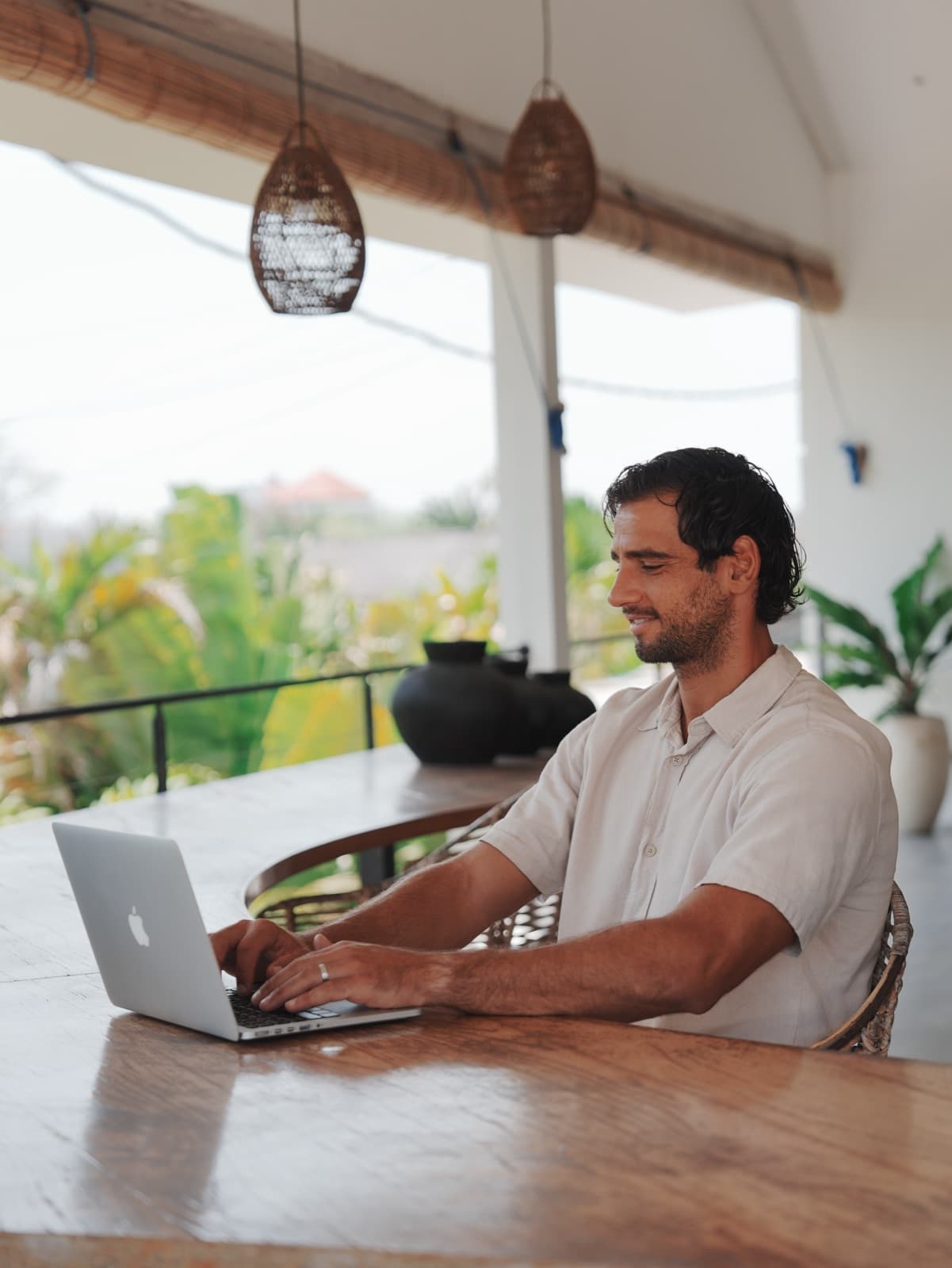 A guest working on a laptop at a long table in the open shared workspace